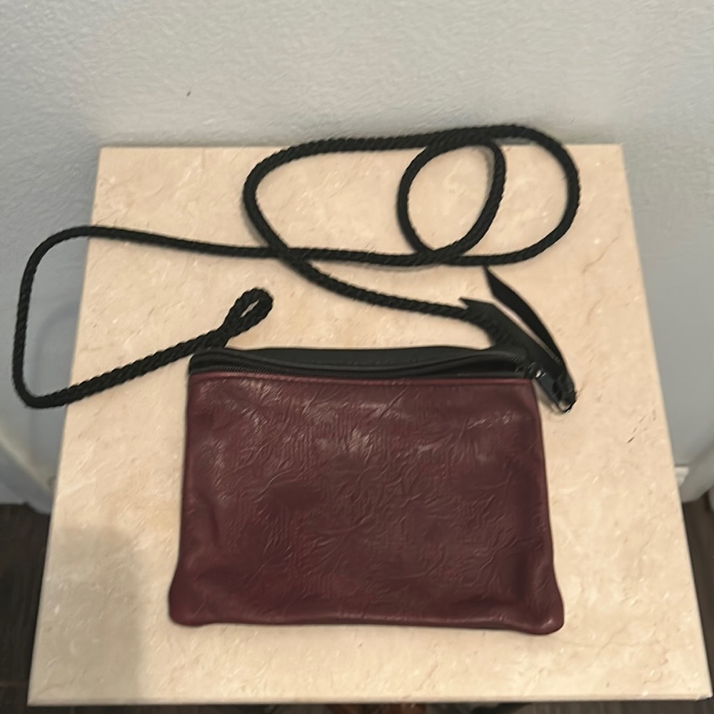 Am embossed leather bag. Perfect for holding $$, phone, lipstick! Burgundy